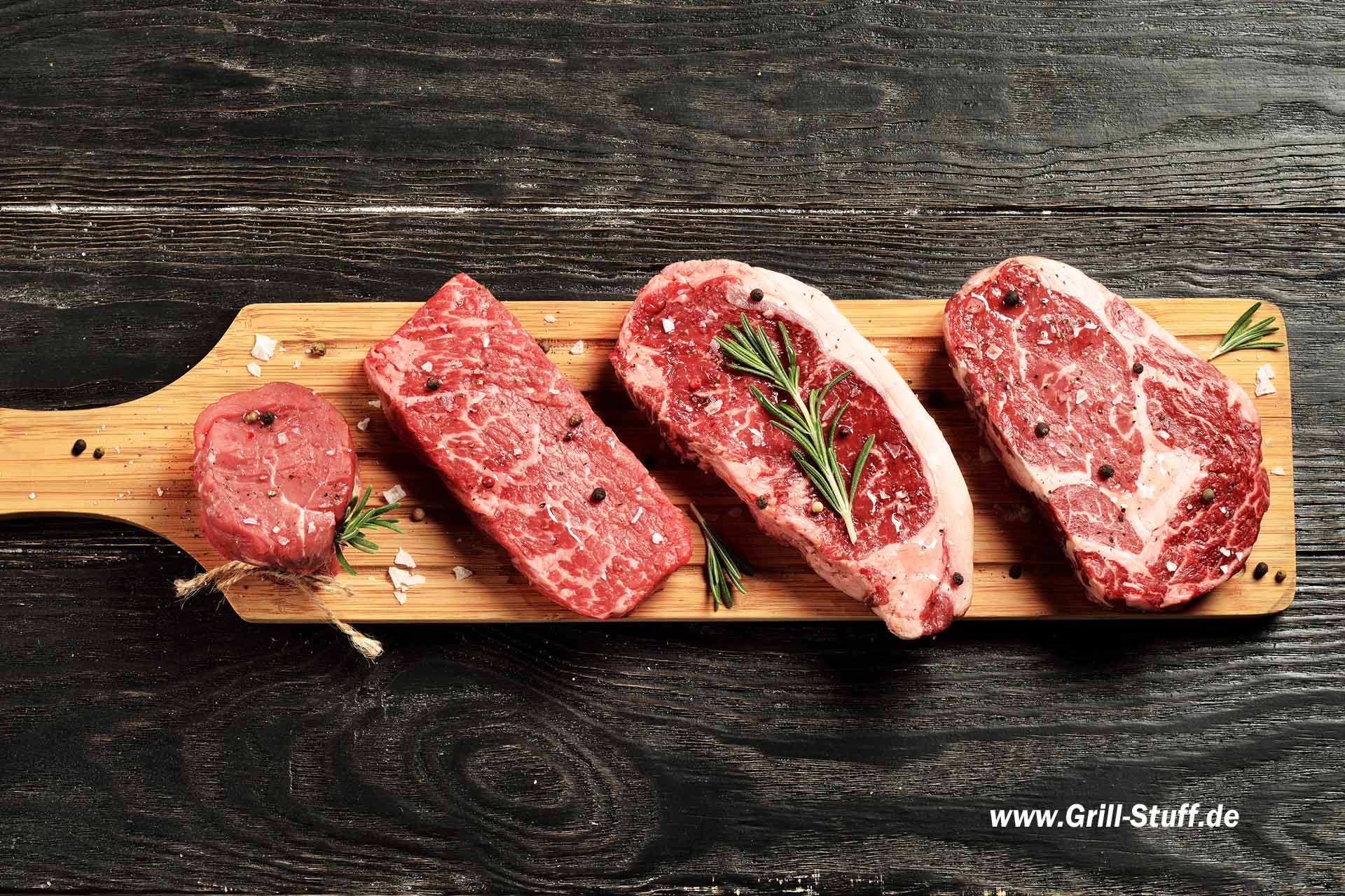 Frische rohe Rindfleischsteaks aus dem Prime Black Angus auf Holzbrett: Tenderloin, Denver Cut, Striploin, Rib Eye Frische rohe Rindfleischsteaks aus dem Prime Black Angus auf Holzbrett: Tenderloin, Denver Cut, Striploin, Rib Eye