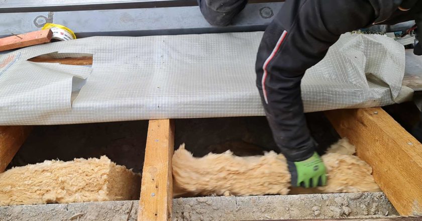 Dachdecker dämmt Dach mit Dämmwolle