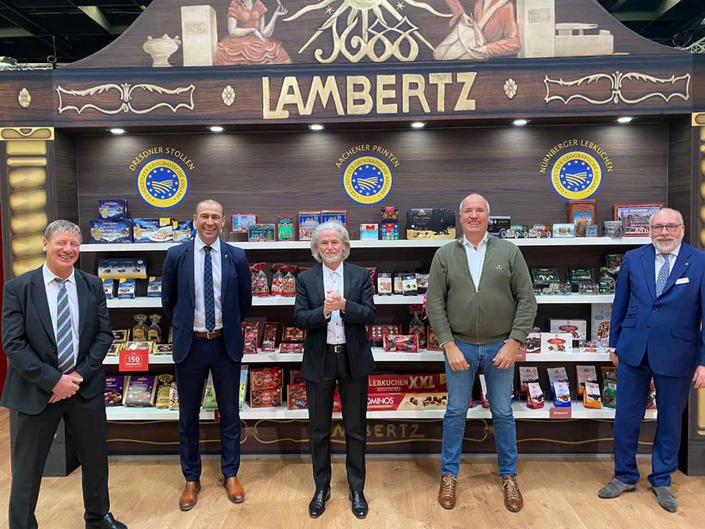 Auf dem Foto sehen Sie den Vorstand des ECKC und sein neuer Preisträger Prof. Hermann Bühlbecker auf dem Lambertz-Messestand im Rahmen der ISM 2022