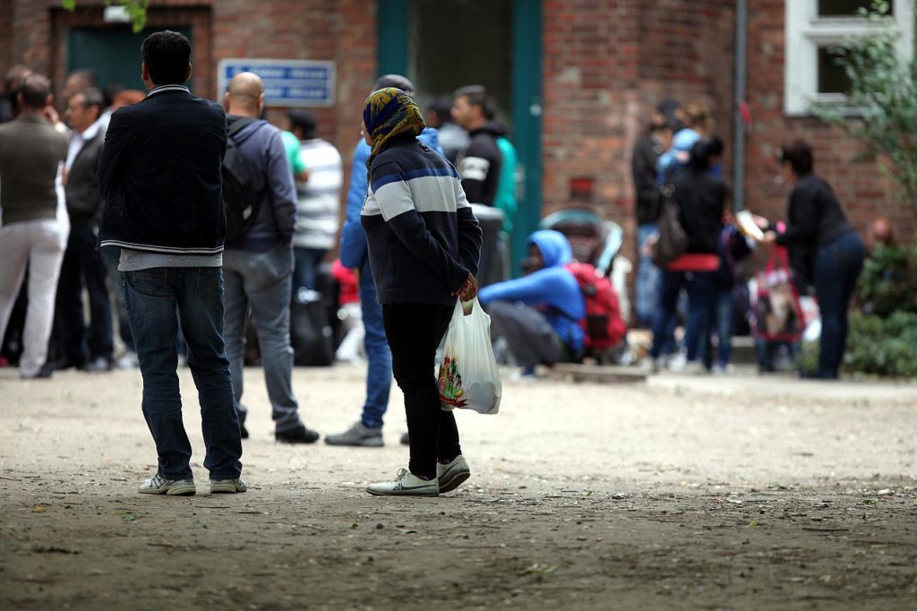 Das Foto zeigt Flüchtlinge an einer Aufnahmestelle