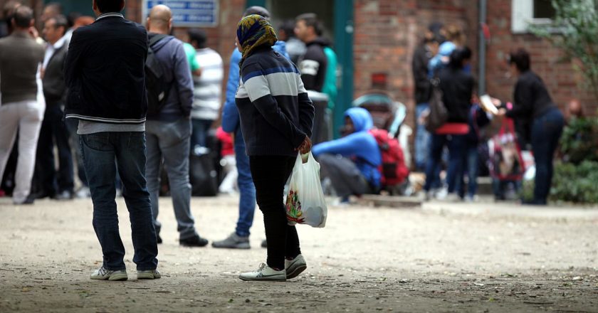 Das Foto zeigt Flüchtlinge an einer Aufnahmestelle