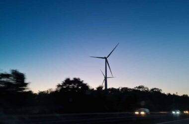 Das Foto zeigt Windräder und ein Wasserstoffauto