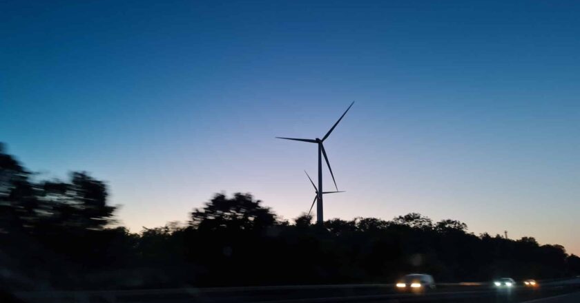 Das Foto zeigt Windräder und ein Wasserstoffauto