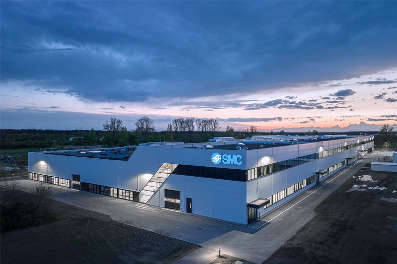 Die neue Produktionshalle von SMC Deutschland GmbH, beleuchtet im sanften Abendlicht.