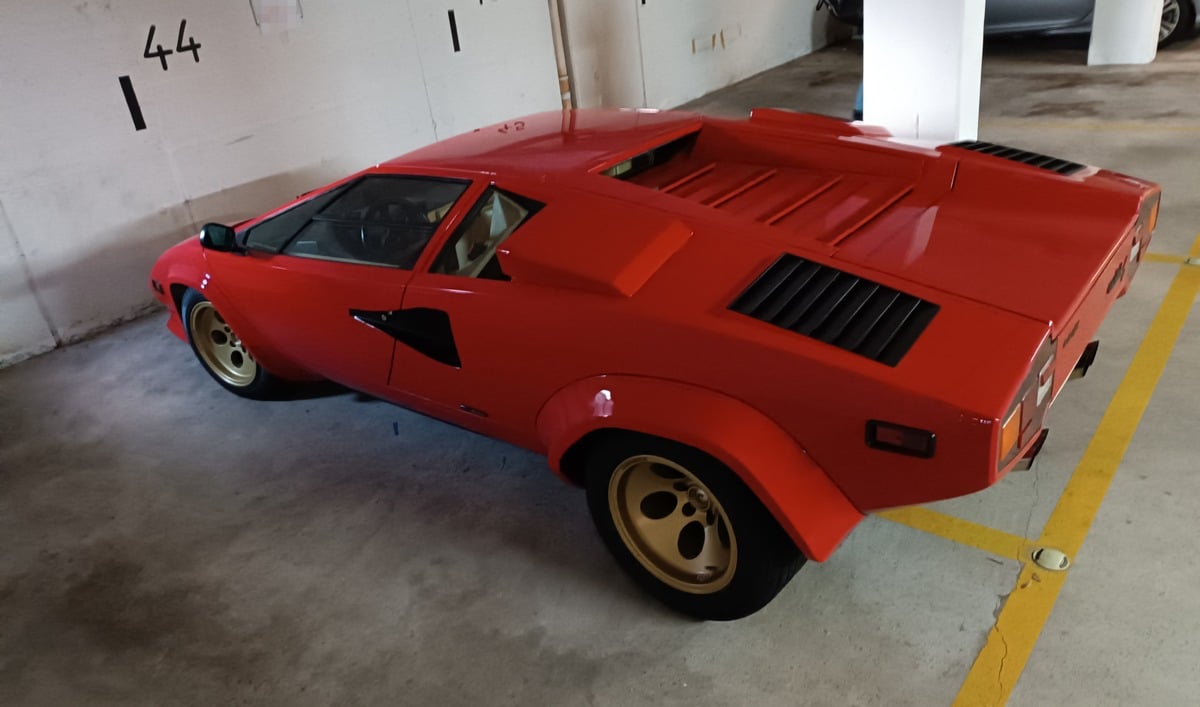 Hintere und Fahrerseite eines gestohlenen roten Lamborghini, zuletzt geparkt in einer Tiefgarage, jetzt gesucht von der Polizei MK.