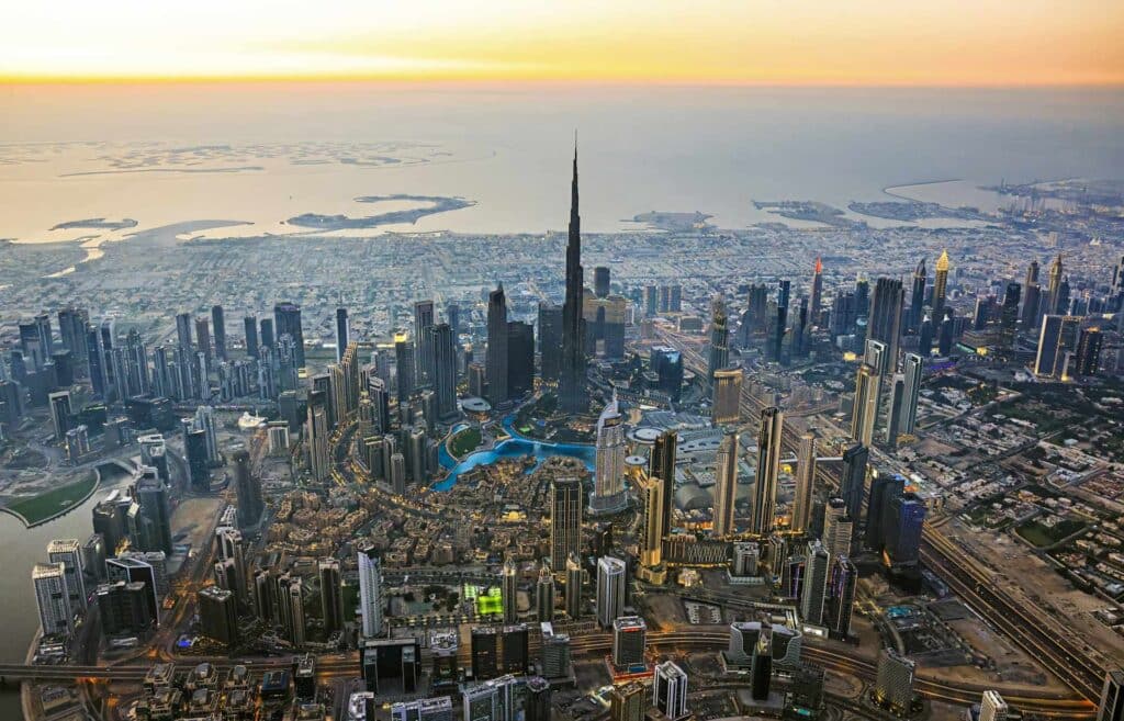 anoramablick auf Dubai bei Sonnenuntergang, mit dem Burj Khalifa im Vordergrund.