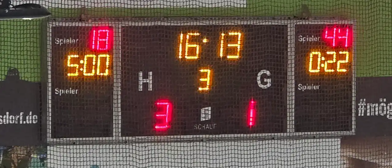 Die Anzeigetafel der Eissporthalle Troisdorf zeigt im dritten Drittel eine verbleibende Spielzeit von 16:13 Minuten. Der Heimverein (H) EHC Troisdorf führt mit 3:1 gegen den Gastverein (G) Eissportclub Rheine. Links ist eine 5-Minuten-Strafe für Spieler Nummer 18 angezeigt, rechts eine 22-Sekunden-Strafe für Spieler Nummer 44.