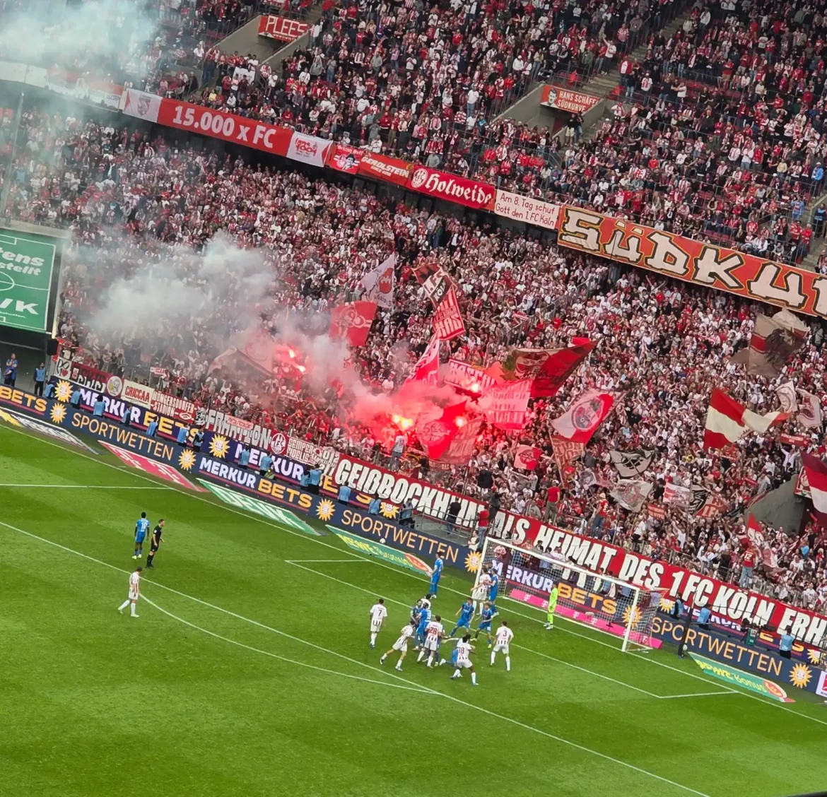 Fans des 1. FC Köln in der Südkurve mit Fahnen, Rauch und Pyrotechnik beim Bundesliga-Spiel gegen den 1. FC Heidenheim.